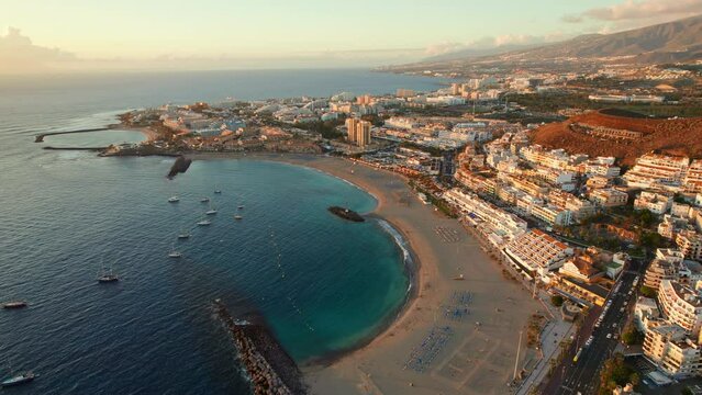 Fuente Playa de Las Vistas beach in Los Cristianos town on Tenerife at sunset