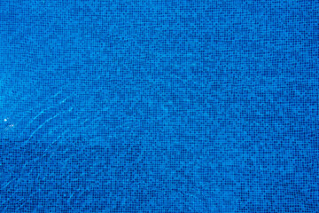 Light reflects off the surface of the blue swimming pool.
