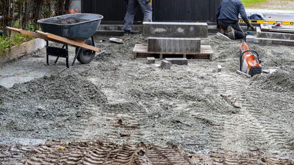 Workers placing cement blocks for a patio floor