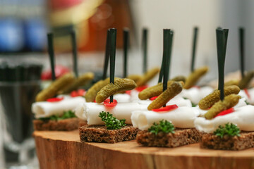 Appetizers made of lard, pickled cucumbers and brown bread stand. Wedding event
