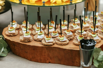 Appetizers made of herring, leek and brown bread stand. Catering buffet table with snacks.