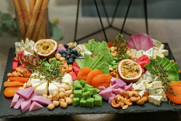 Cheese plate with rosemary and nuts on wooden board. Wedding event