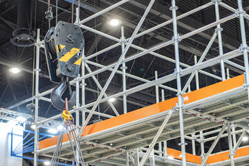 Lifting hook at moment of lifting load. Rigging near mezzanine in hangar. Lifting hook for cargo work. Construction equipment. Rigging hook for moving heavy objects. Construction background