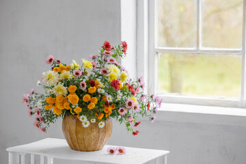 bouquet of colorful chrysanthemums in vase in white old interior
