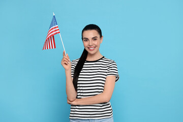 4th of July - Independence Day of USA. Happy woman with American flag on light blue background