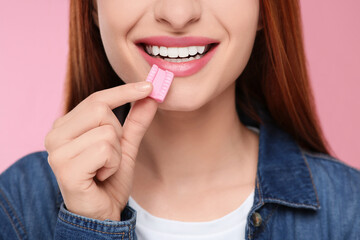 Woman with bubble gum on pink background, closeup