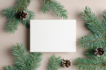 Fototapeta na wymiar Blank Christmas holiday greeting card mockup with envelope and fir tree branches with cones