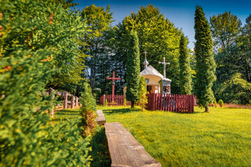 Green summer view on small chapel on historical place - Dovbush Rocks. Colorful morning scene of Carpathian mountains, Ukraine, Europe. Traveling concept background..