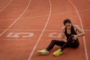 Woman runner has twisted ankle injury while practice marathon run at the racetrack.