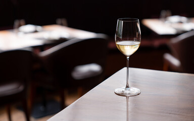 White wine in the wineglass on the table in restaurant.