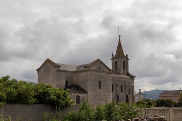 Fototapeta na wymiar Historic Stone Church Under a Cloudy Sky in a Small Town