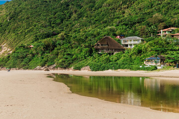 Fototapeta na wymiar Sandy beach with houses on mountain in Brazil