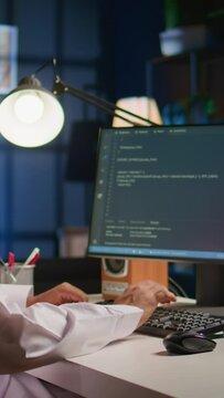 Vertical video Technician writing script code on computer screen using Java programming languages for outsourced project. Teleworking employee at home fixing intranet database errors, handheld camera