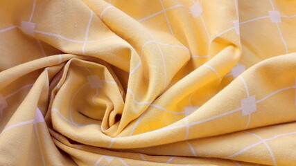 Yellow cotton fabric with geometric patterns. Fabric texture. Viscose, cotton. Colored bright summer fabric.
