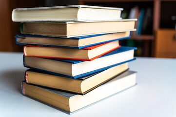 Stack of books, photographed closely, on white surface.
