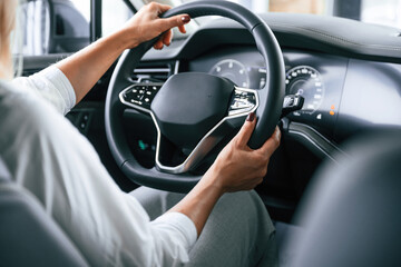 Modern quality interior. Woman is sitting in a car and driving it