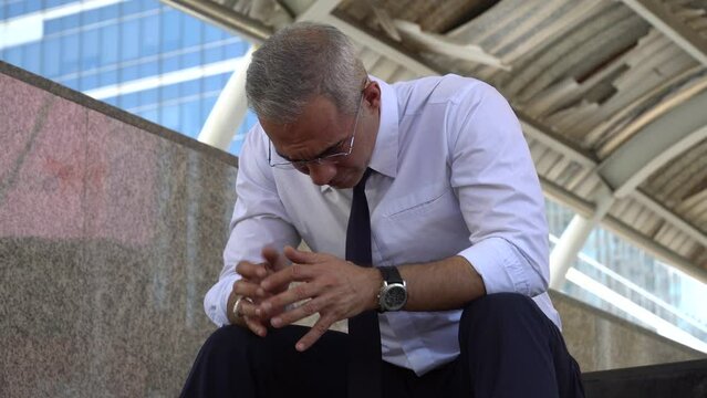 senior businessman Stressed and worried about the economic situation and war, unemployment and inflation outdoors