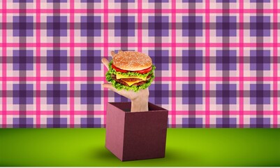Human hand sticking from box with burger