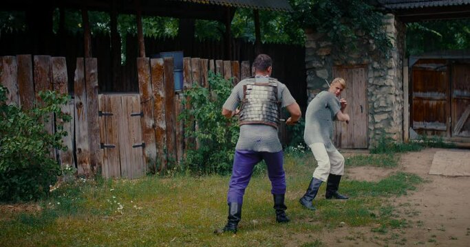 historical reenactment, two young adult men fighting with swords, medieval ages, 4K, Prores