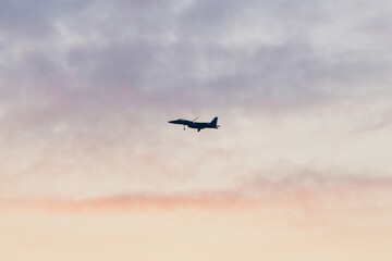 Fototapeta na wymiar 美しい夕空を滑空する戦闘機