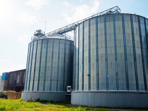 Paddy rice storage steel silo in a milling plant. Agriculture produces storage technologies. Paddy, grain, and corn storage vertical warehouse.
