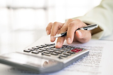 Hand of Business people calculating interest, taxes and profits to invest in real estate and home buying