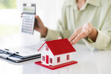 Hand of Business people calculating interest, taxes and profits to invest in real estate and home buying