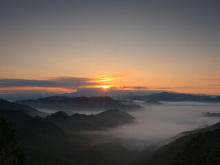 朝日が昇る雲海の山