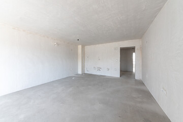 New empty room under construction. Plaster walls. New home. Concrete walls. Interior renovation.