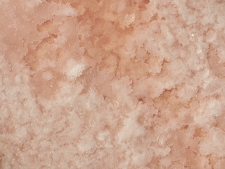 Natural pink salt crystal texture in water, macro, close-up photo. Salty lake shore drying during...