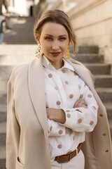 Fototapeta premium Fashion woman wearing beige coat on the street