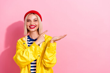 Photo of nice model young woman wear gore tex technology raincoat point finger holding novelty hand isolated on pink color background