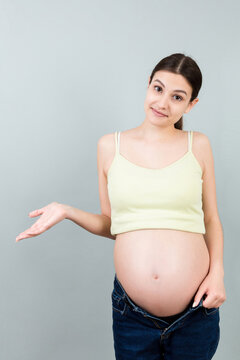 Picture of shocked or surprised pregnant lady standing over colored background. Looking at camera