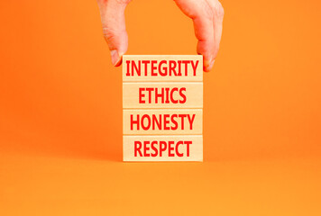 Integrity ethics honesty respect symbol. Concept word Integrity Ethics Honesty Respect on block. Beautiful orange background. Businessman hand. Business integrity ethics honesty respect concept.