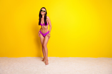 Full size photo of cheerful stunning slender figure girl stand sand beach posing empty space ad isolated on yellow color background