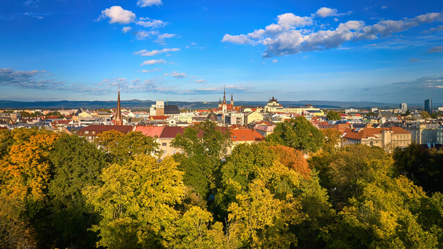 Panoramic view through autumn-coloured trees to the towers and temples of the centre of Olomouc, the historical centre of Moravia, Czech republic, UNESCO site. Autumn, sunny day, view from the air.