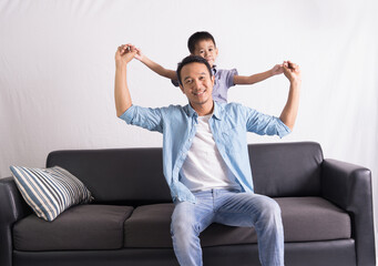 happy asian Father and son are sitting on the couch. Cute boy with dad playing at home. happy family, father day