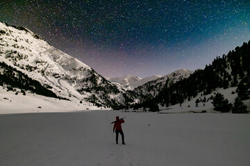 hiker enjoying stargazing in a snowy mountain landscape