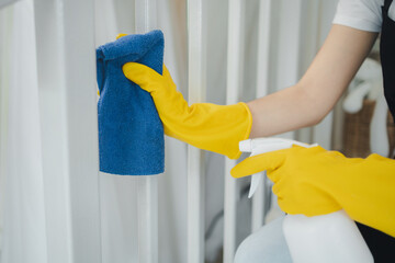 Housekeeper cleaning the furniture at home, Wear an apron and rubber gloves to protect against cleaning chemicals, female wiping down stairs with cleaning spray, cleaning idea.
