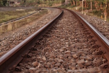 Obraz premium Photo of railroad tracks running diagonally through the picture with partially visible platform as concept for direction travel sadness and loneliness
