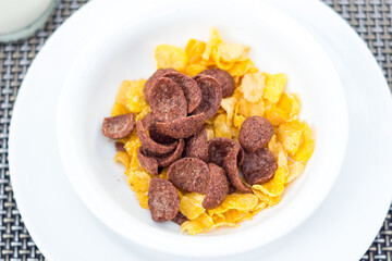 Breakfast with milk pouring in corn flakes
