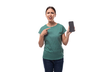 a young charismatic black-haired woman with gathered hair is dressed in a basic t-shirt and jeans, pointing her finger at the smartphone screen in surprise