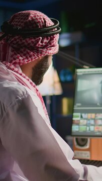 Vertical video Arabic colorist freelancer editing outsourcing cinematographic project, creating content creation stock footage, working with images and sounds. Teleworking worker processing movie on
