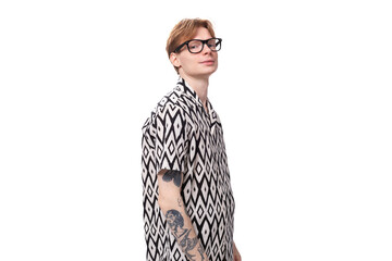 a young stylish man with red hair and a tattoo on his arms is dressed in a short-sleeve shirt with...