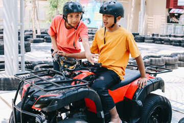 Fototapeta na wymiar Boys having fun riding quad bike or ATV 