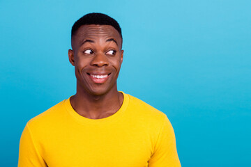 Photo of funny impressed man with stylish haircut dressed yellow shirt staring at sale empty space isolated on blue color background