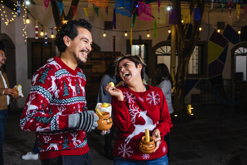 Obraz premium Mexican young couple or friends having fun in posada celebration for Christmas in Mexico Latin America 