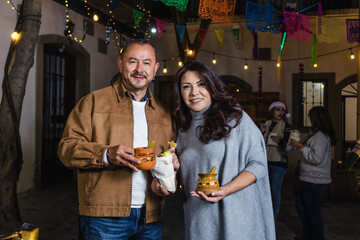 Mexican mature couple having fun in posada party for Christmas celebration traditional in Mexico...