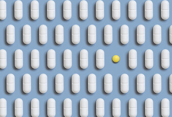 Mix of white medical pills in a line with one yellow on light blue top view. Dietary supplements