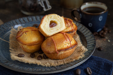 Pasticciotto leccese pastries on a dark blue plate near coffe cup on dark table close up